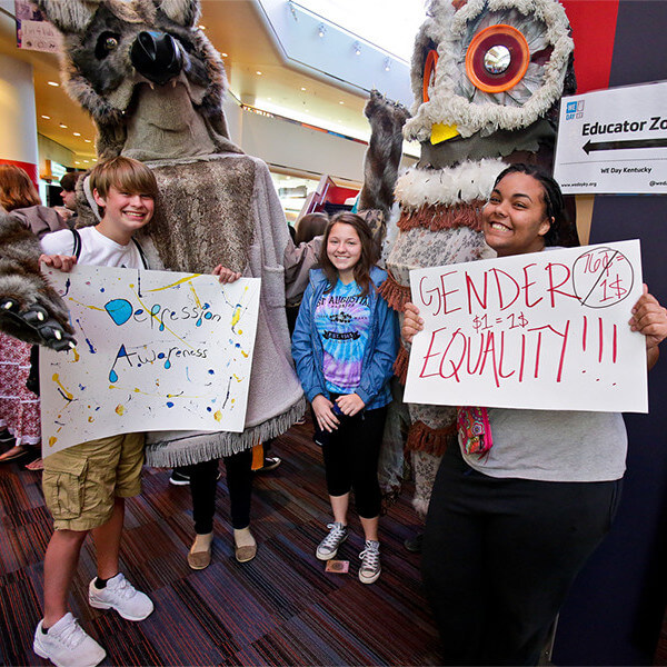 WeDay Students holding signs: Gender Equality and Depression awareness